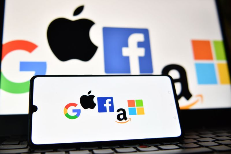 Uma imagem ilustrativa tirada em Londres em 18 de dezembro de 2020 mostra os logotipos do Google, Apple, Facebook, Amazon e Microsoft exibidos em um telefone celular e em uma tela de laptop. (Foto por JUSTIN TALLIS / AFP) (Foto por JUSTIN TALLIS/AFP via Getty Images)